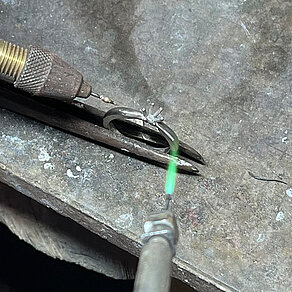 Fachgerechte Reparatur von Fassungen Ring mit Krappenfassung wird auf der Werkbank mit einer Flamme erhitzt