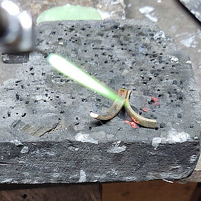 Präzise Lötarbeiten für passgenaue Ergebnisse Zwei Ringteile werden auf einer Lötunterlage mit einer Flamme erhitzt